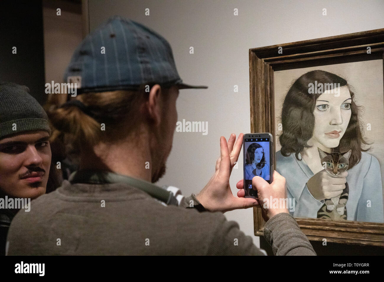Moscow, Russia. 22nd Mar 2019. Visitor make a photo of the painting 'Girl with a Kitten'' of Lucian Freud in the Pushkin State Museum of Fine Arts during the exhibition “Francis Bacon, Lucian Freud, and the School of London.” in Moscow, Russia. The artworks provided by the Tate Gallery, London. Stock Photo