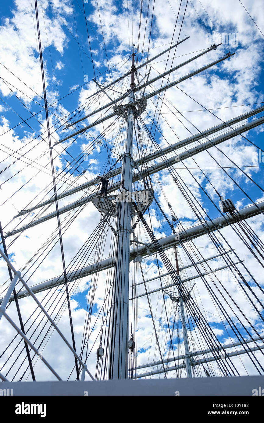 Close up view from old sailboat ship high mast and ropes against clouds and sky Stock Photo