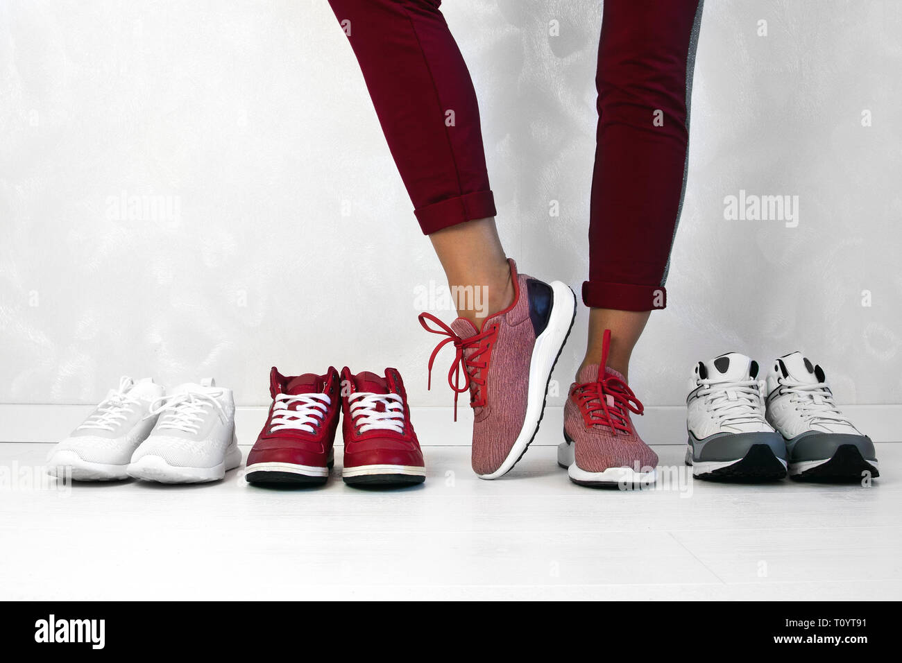 Sports girl chose a pair of sneakers among others. Stock Photo