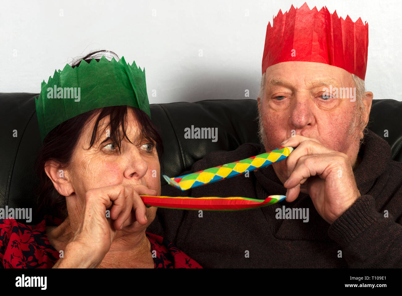 Elderly couple wearing paper Christmas cracker hats Stock Photo