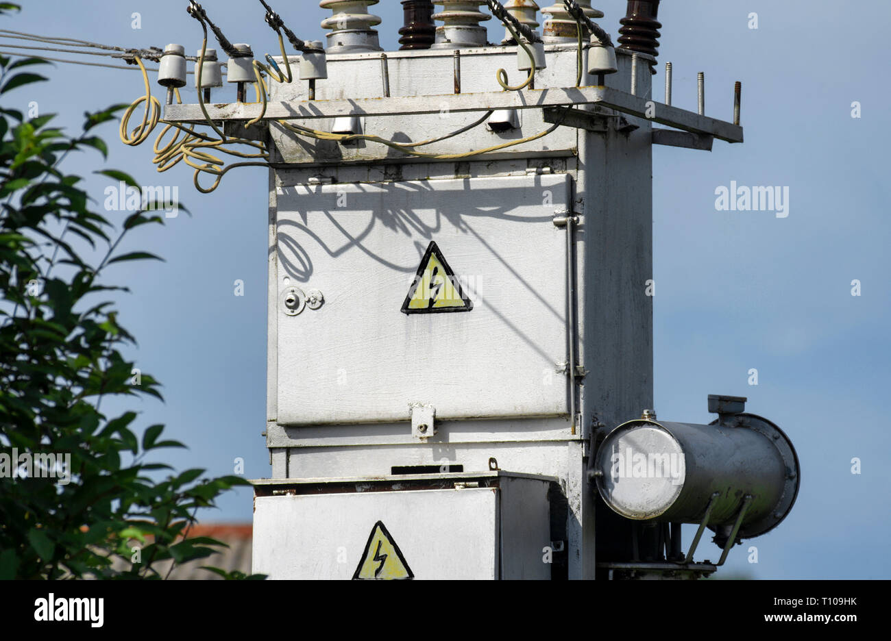 Power system with electrical panel with warning signs 'electric shock' on the background of the blue sky close-up Stock Photo
