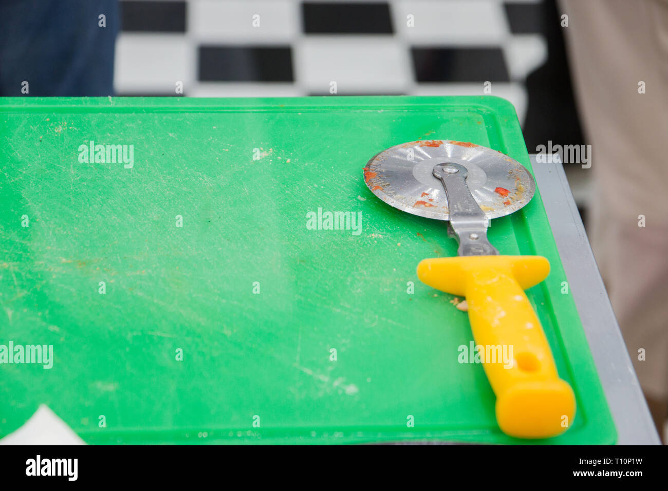 Pizza cutter on green desk. Stock Photo