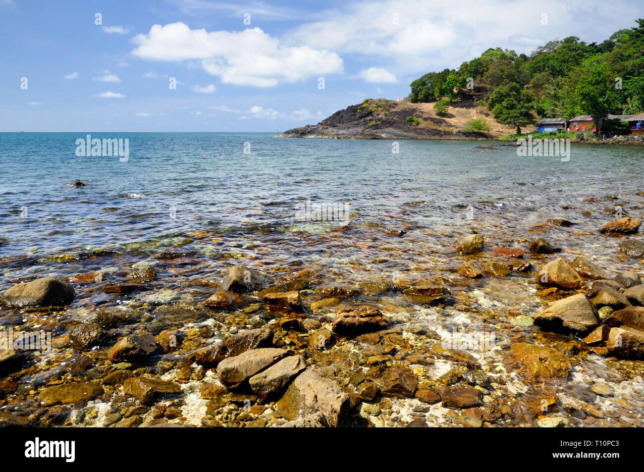 Volcanic rock beach and tourist resort at the coastline of the tropical Koh Chang Island, Thailand. Stock Photo