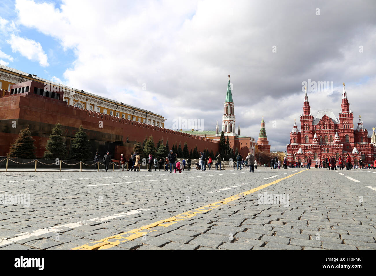 Red square in Moscow in early spring, scenic panorama with beautiful sky and clouds. Tourists walking along Kremlin wall and Lenin mausoleum Stock Photo