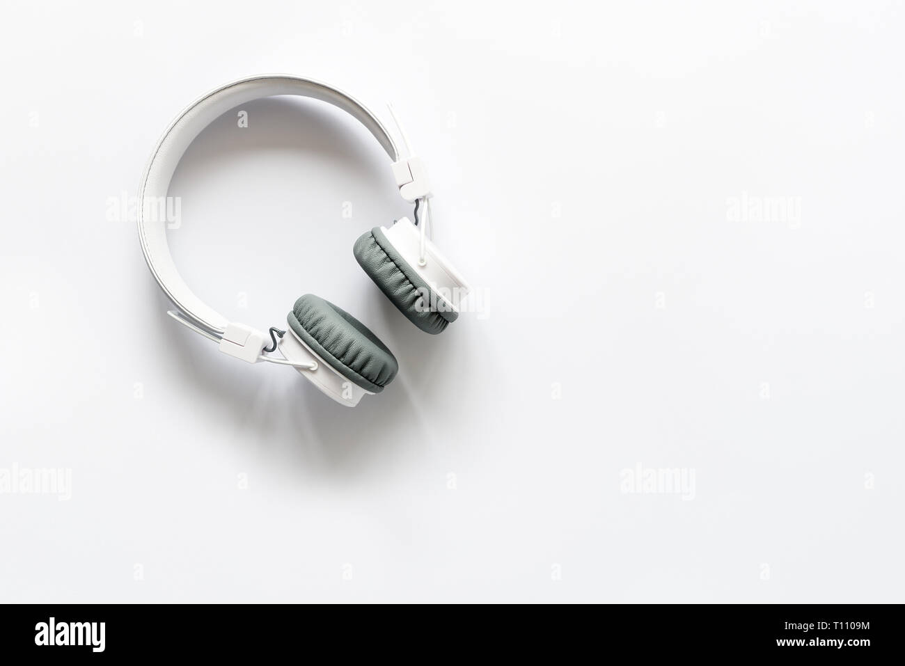 White wireless headphones on white background. Top view. Copy space ...