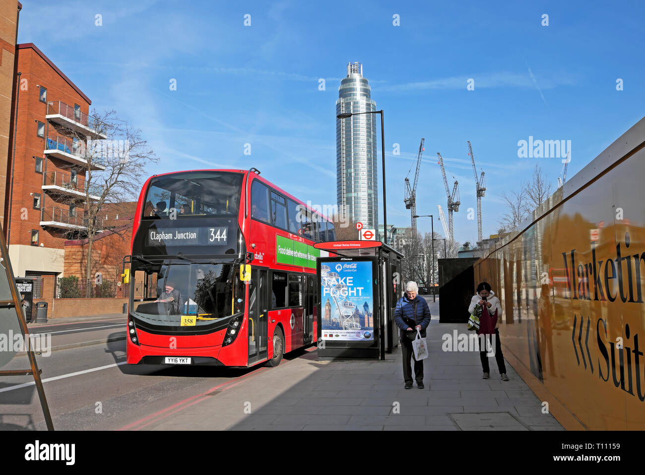A red double decker 344 bus Clapham Junction at bus stop by American Embassy on Nine Elms Lane street view of St George tower London UK  KATHY DEWITT Stock Photo