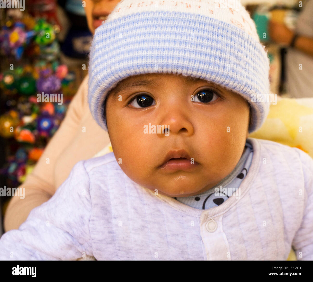 A very cute Mexican baby several months old with his mother in the main market in La Paz, Mexico. Stock Photo