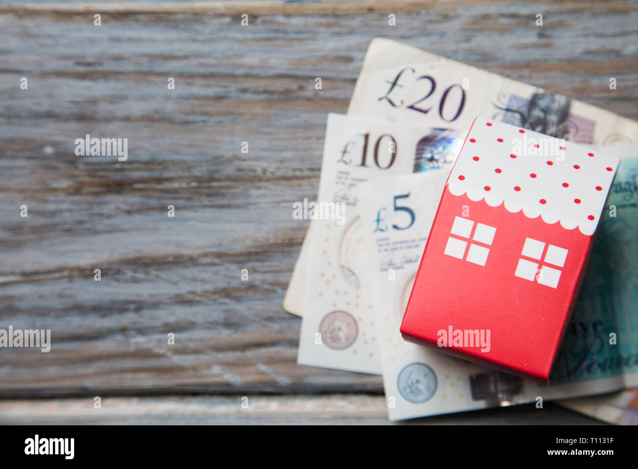 Housing cost. Paper toy house with British currency notes Stock Photo