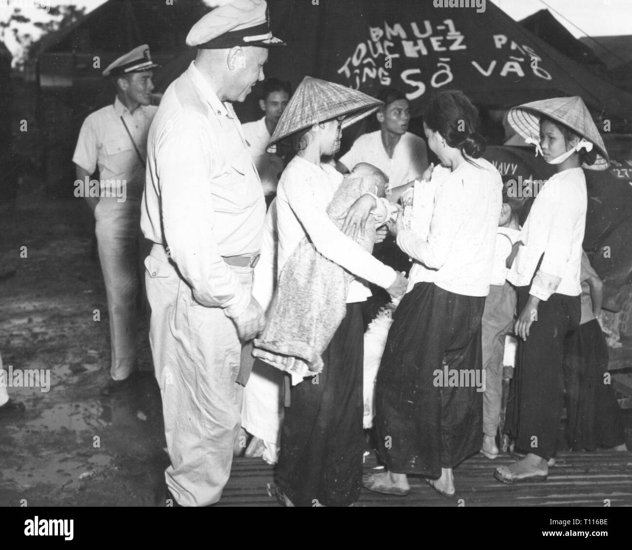 Indochina War 1946 - 1954, mass evacuation of Vietnamese civilians from Haiphong to Saigon, September 1957, captain Julius Amberson, chief of the preventive medicine division at the Naval Hospital in Bethesda, Maryland, is inspecting a refugee camp, navy physician, physician, physicians, medical care, US navy, medical service, first aid, United States Navy Medical Corps, USA, United States of America, American, women, evacuation, evacuations, flight, misery, hardship, people, war, wars, Indochina, Viet Nam, Vietnam, 20th century, 1950s, civilian,, Additional-Rights-Clearance-Info-Not-Available Stock Photo