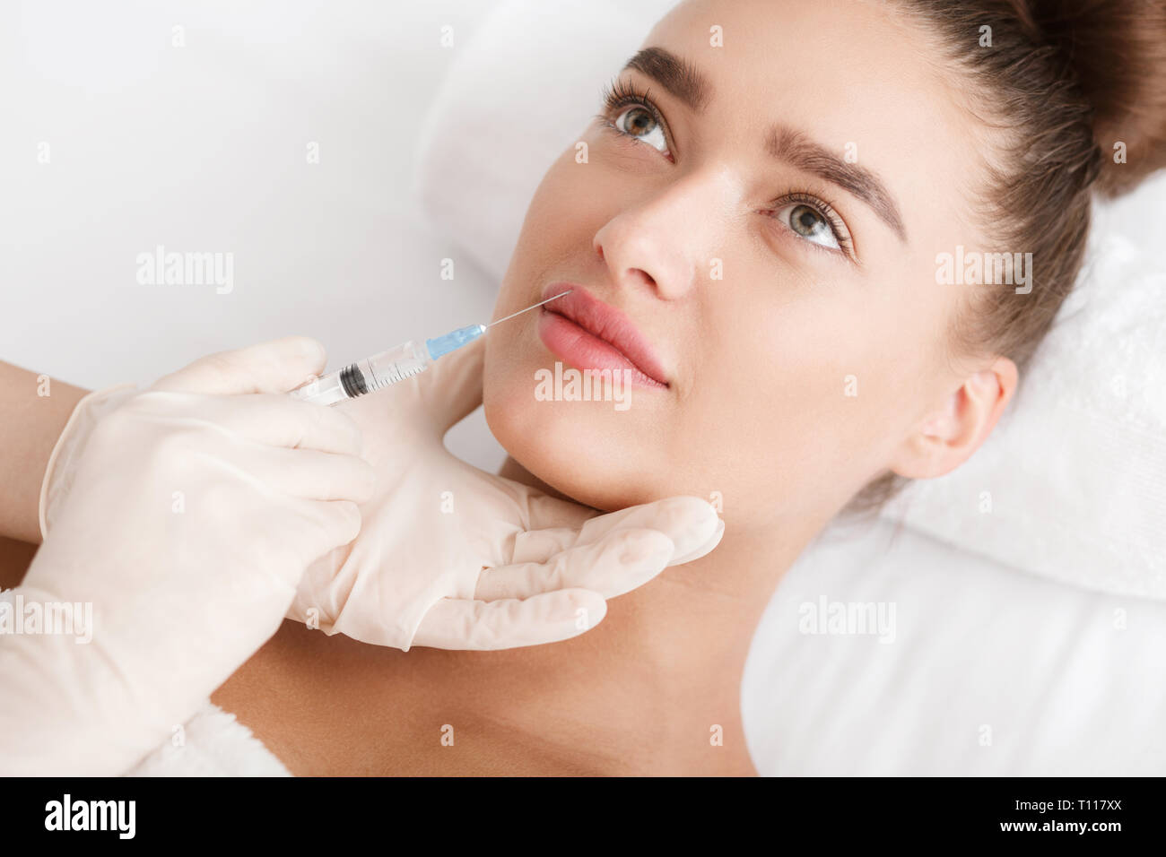 Lip augmentation. Young woman receiving acid injection Stock Photo