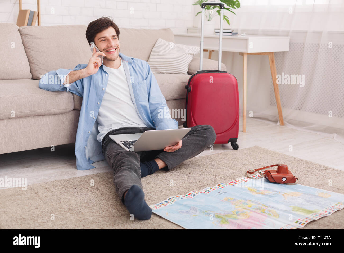 Young man preparing for vacation, consulting with agent Stock Photo