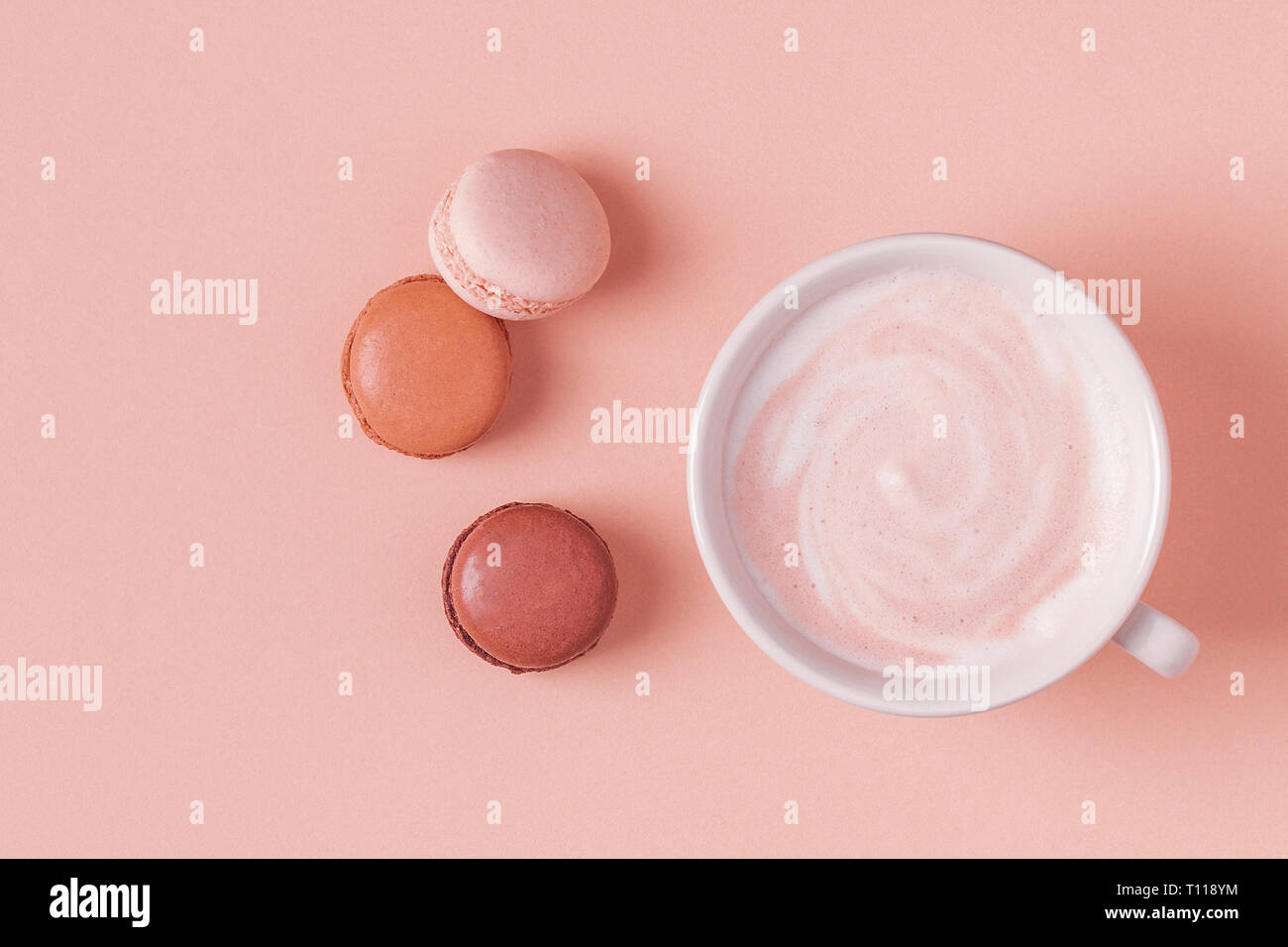 Cup of coffee with macaroons on pastel background, flat lay. Stock Photo