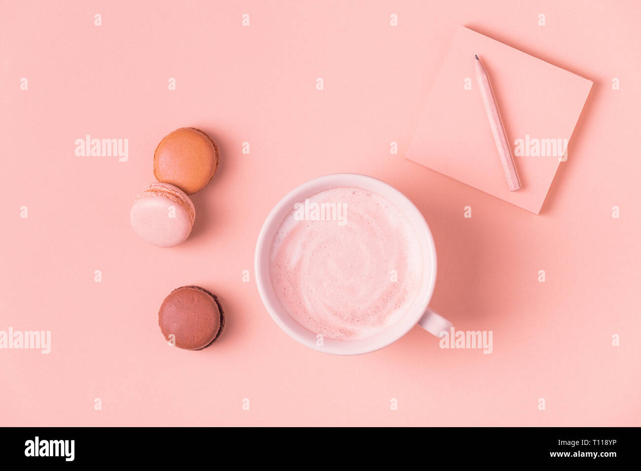 Cup of coffee with macaroons on pastel background, flat lay. Stock Photo