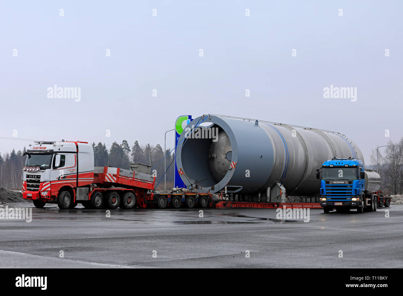 Forssa, Finland - March 16, 2019: Scania 144G tank truck looks small compared to Sisu Hauler and large silo exceptional load of 45 metres and 156 Ton. Stock Photo
