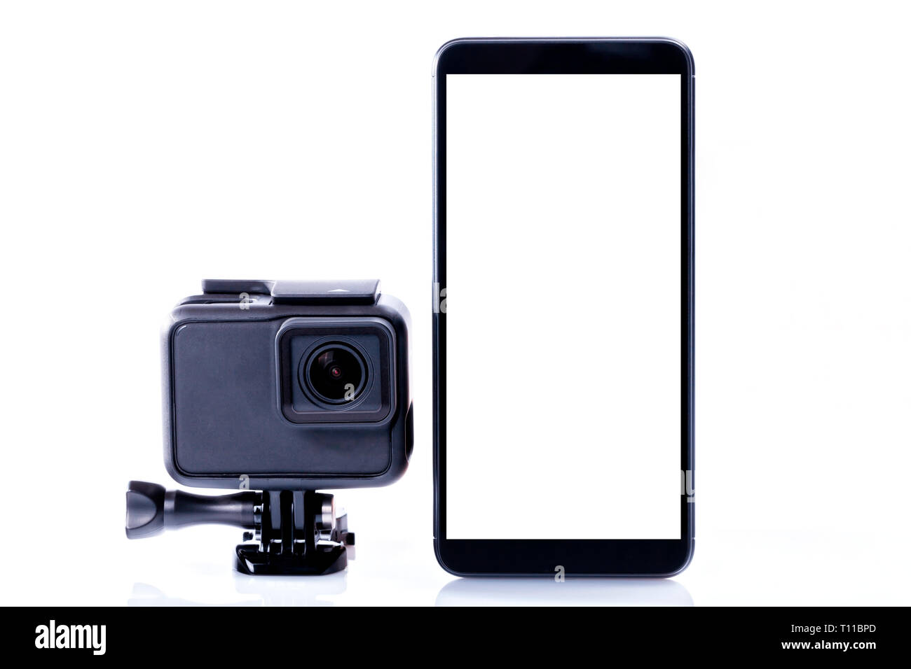A modern video sports camera next to a black smartphone with screen in blank isolated on white. Stock Photo