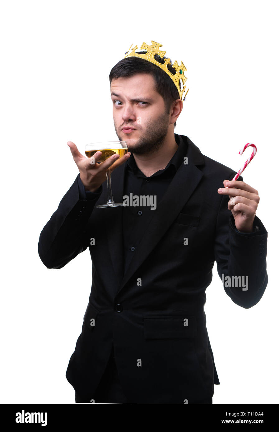 Serious man in crown, black suit with wine glass. Stock Photo