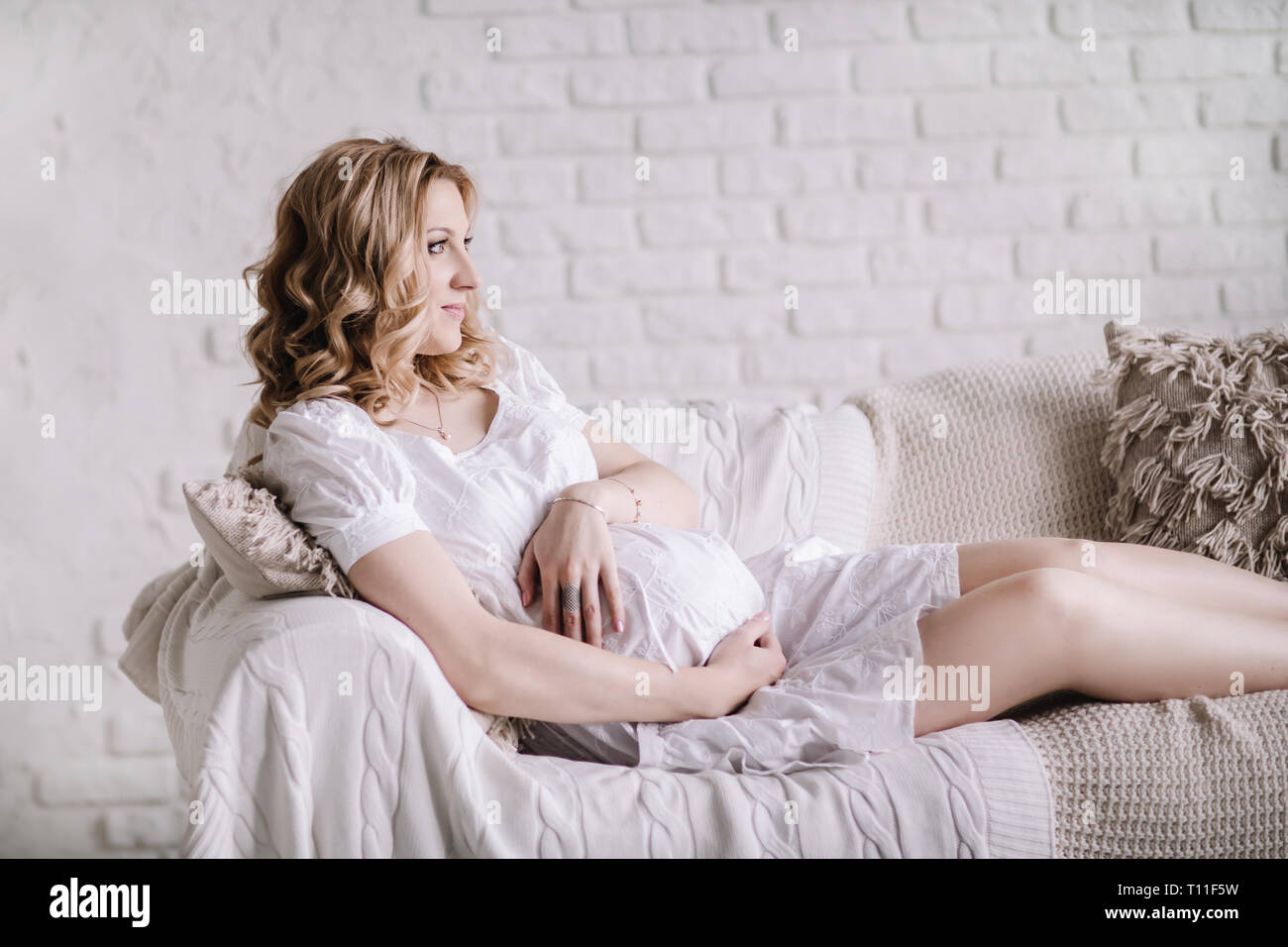 happy young pregnant woman hugging her belly Stock Photo - Alamy