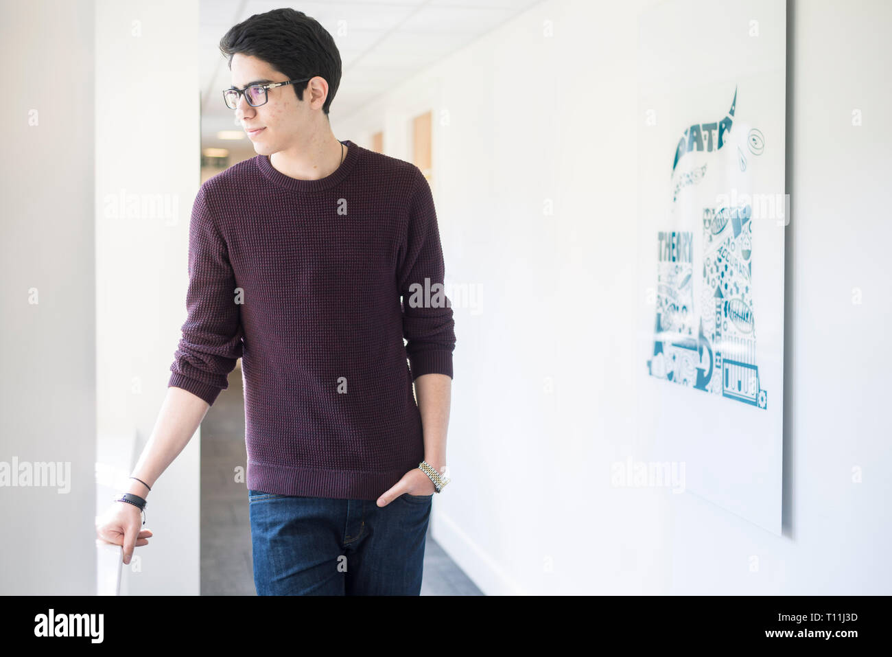 A confident arabic student from the middle east stands in a corridor in a Cambridge college. Stock Photo