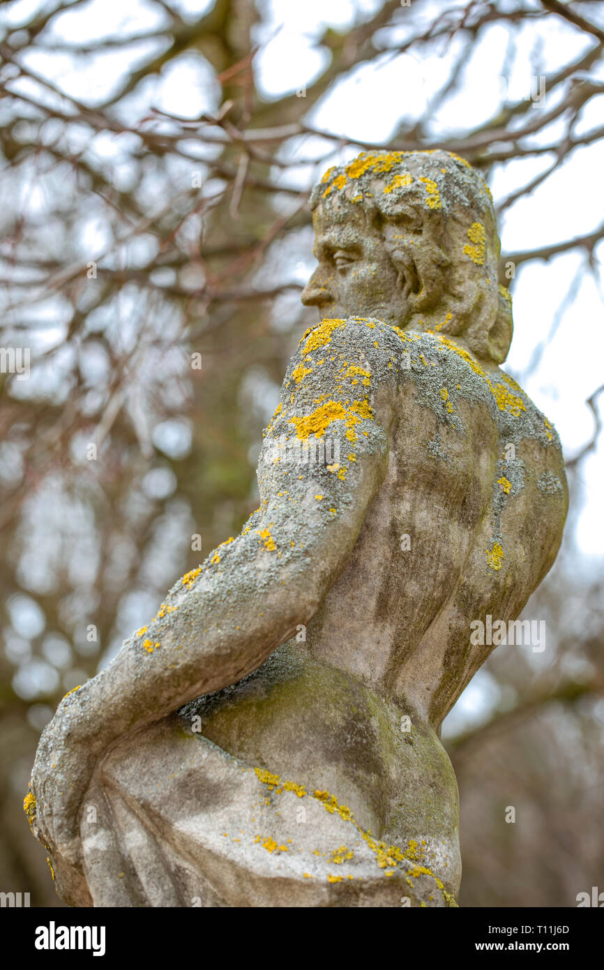 Moss on an old stone goddess statue in the park in Rogalin / Poland