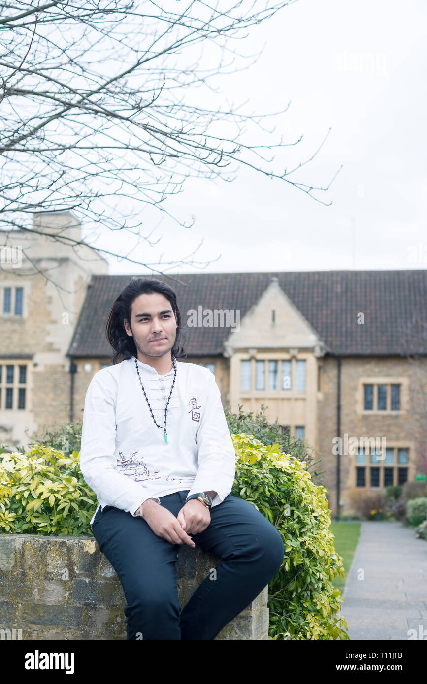 A confident male Middle Eastern international student in the square of an oxbridge college Stock Photo