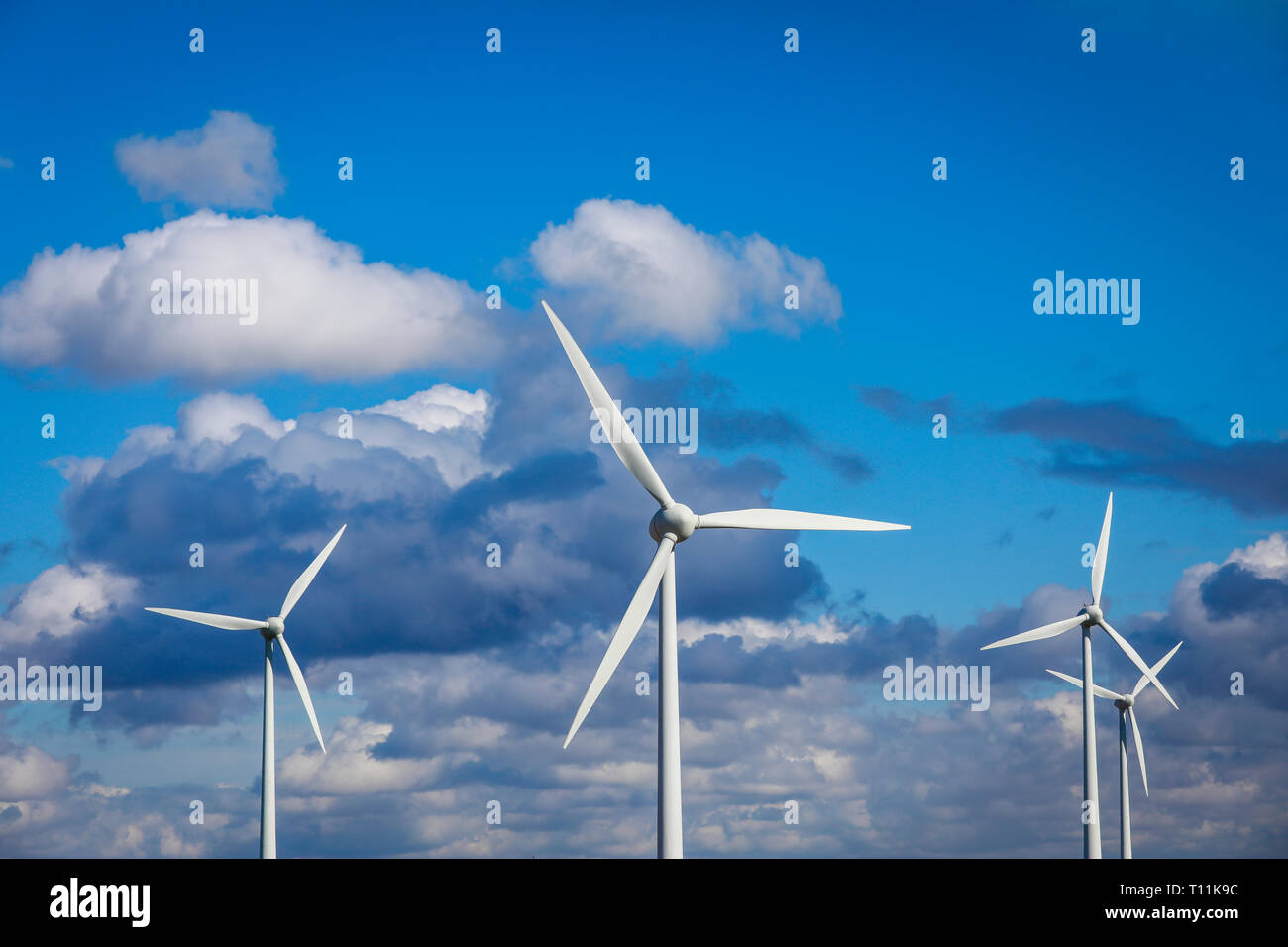 Ense, North Rhine-Westphalia, Germany - Windmills against a blue sky with clouds. Ense, Nordrhein-Westfalen, Deutschland - Windraeder vor blauem Himme Stock Photo