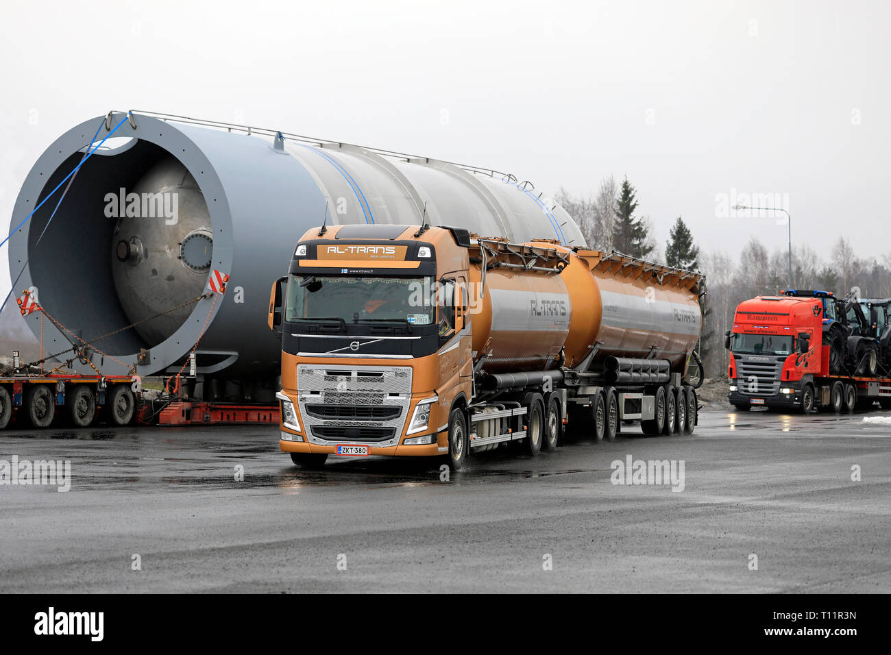 Forssa, Finland - March 16, 2019: Volvo FH 500 truck RL-Trans and 6-axle trailer leaves truck stop with large oversize load parked on the background. Stock Photo