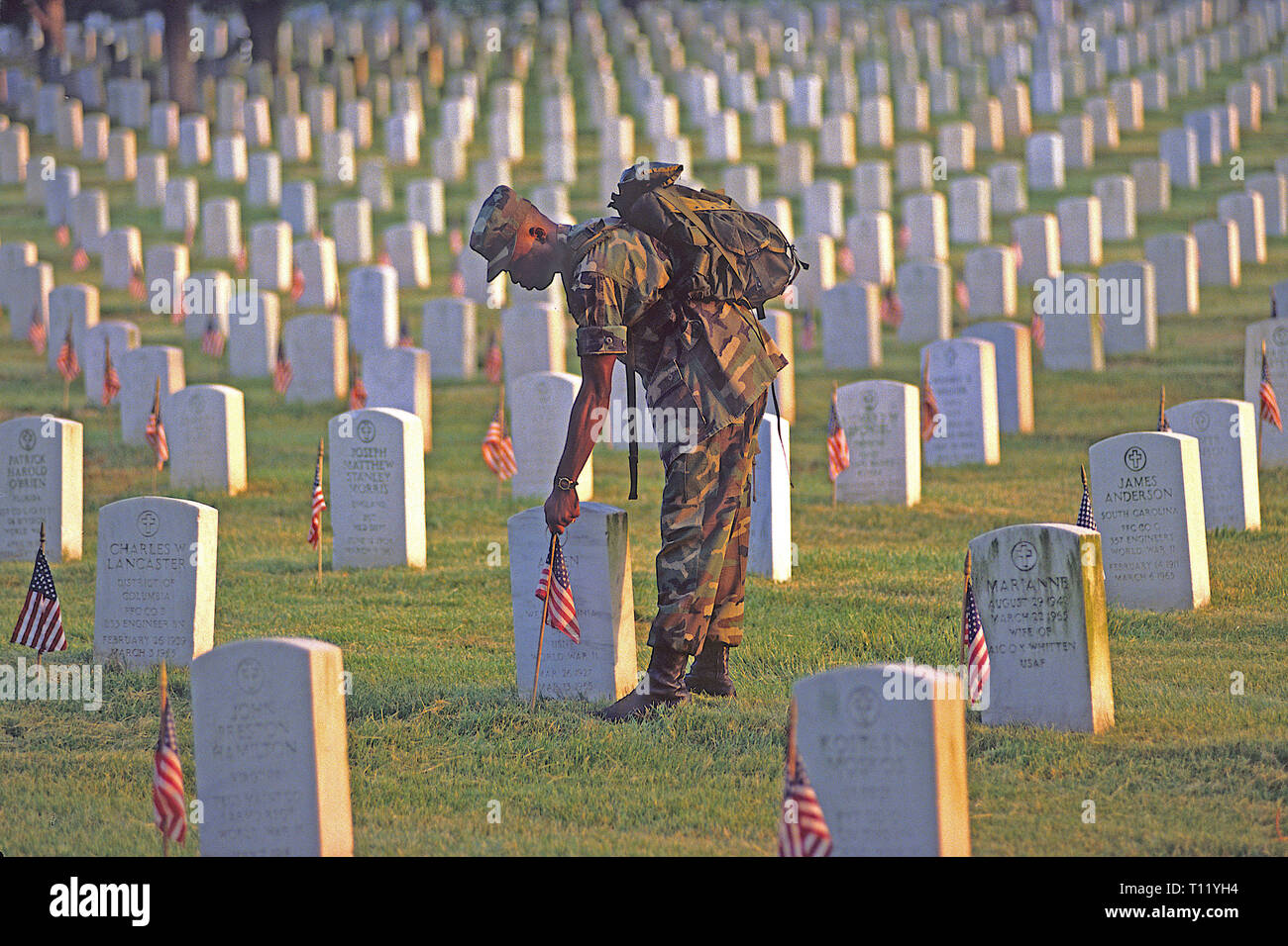 Arlington, Virginia, USA, 30th May,1994 Army soldier places flags on every grave site on Memorial Day at Arlington National Cemetery, in Arlington County, Virginia, directly across the Potomac River from the Lincoln Memorial, is a United States military cemetery beneath whose 624 acres  have been laid casualties, and deceased veterans, of the nation's conflicts beginning with the American Civil War, as well as reinterred dead from earlier wars. Credit: Mark Reinstein/MediaPunch Stock Photo