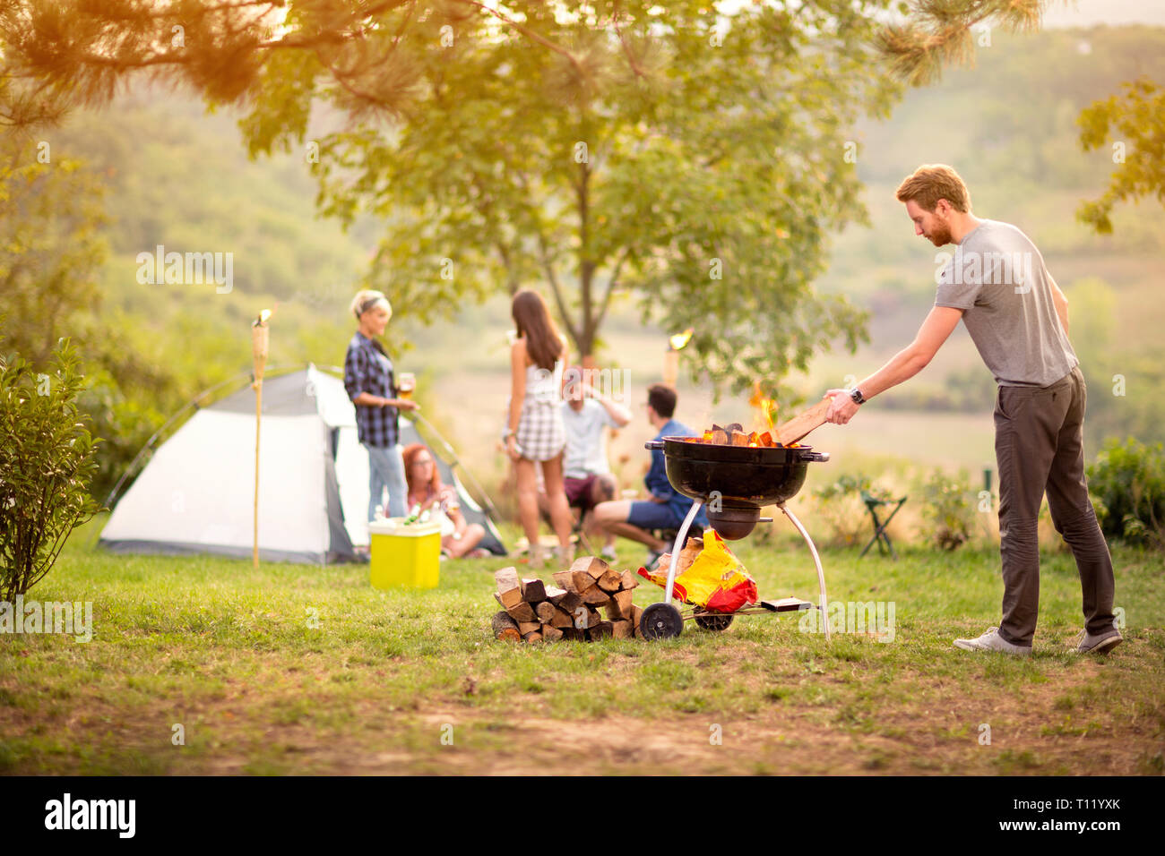 Boy prepare fire for grilling in nature Stock Photo