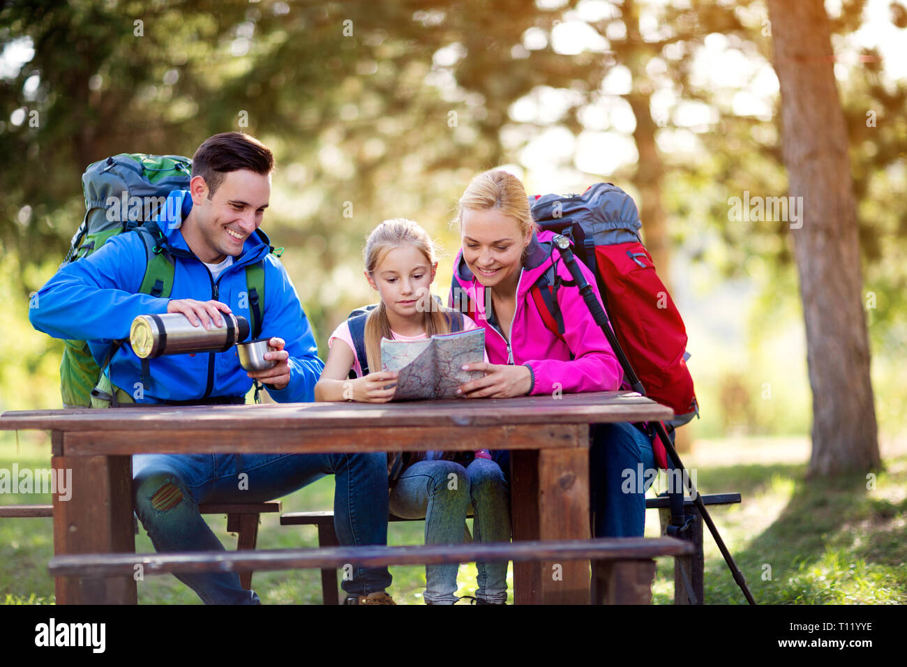 hiking family relax sitting and look on the map in the forest Stock Photo