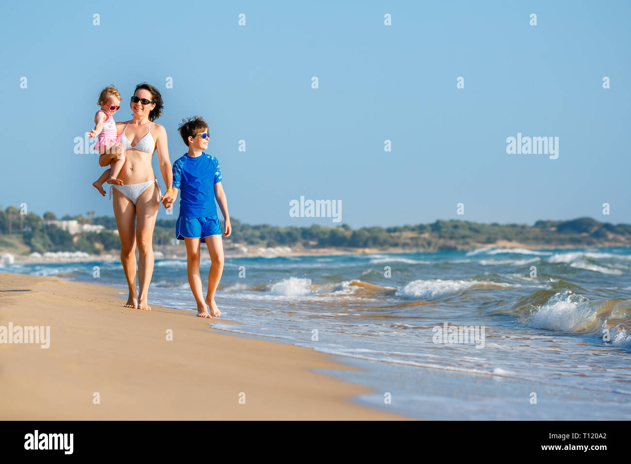 Young mother with her two kids on tropical beach during summer holiday vacation Stock Photo