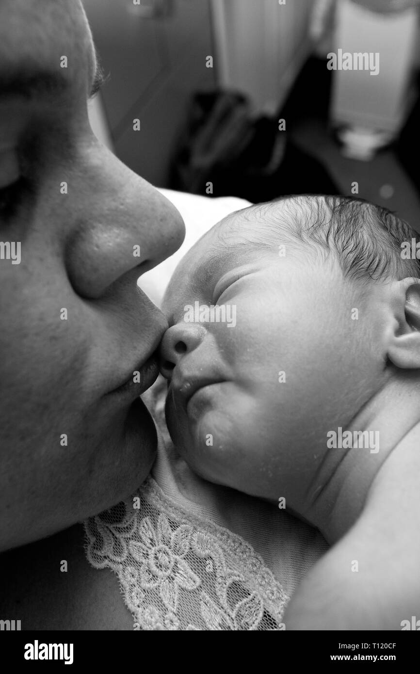 Newborn baby being kissed by mum. MR available. Stock Photo