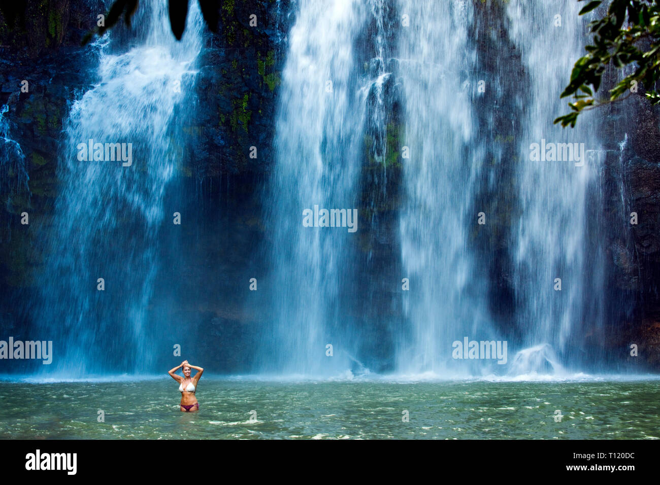 Central America, Costa Rica, Cataracta Llamos de Cortes. Woman enjoying plunge pool of tropical waterfall. Stock Photo