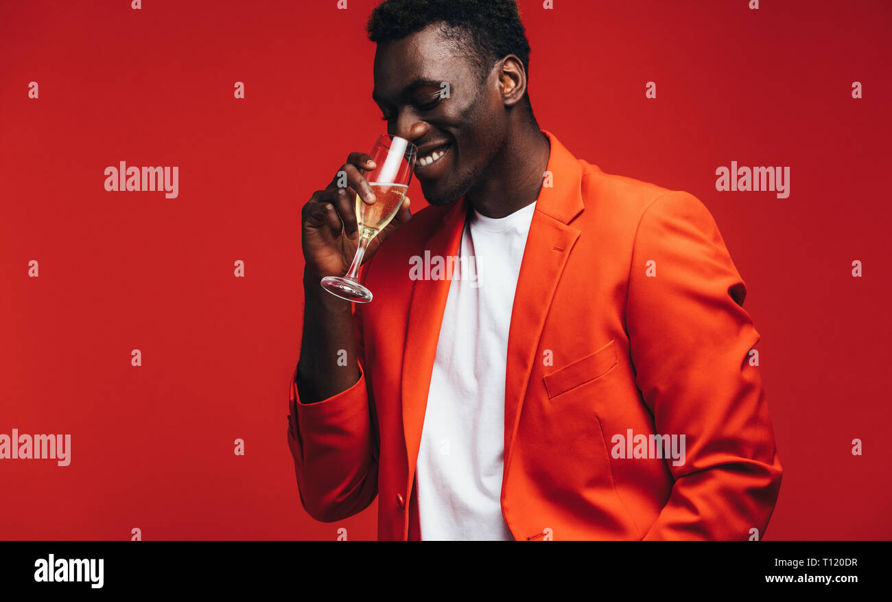 Stylish young man in red jacket drinking champagne. African american ...