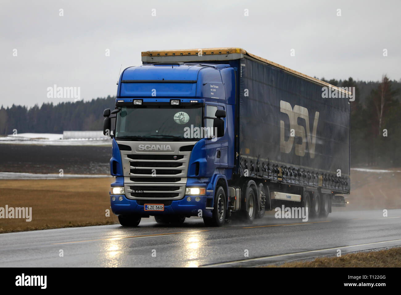 Salo, Finland - March 8, 2019: Blue Scania R440 truck of Ismo Partanen pulls semi trailer along wet highway on a rainy day of early spring in Finland. Stock Photo