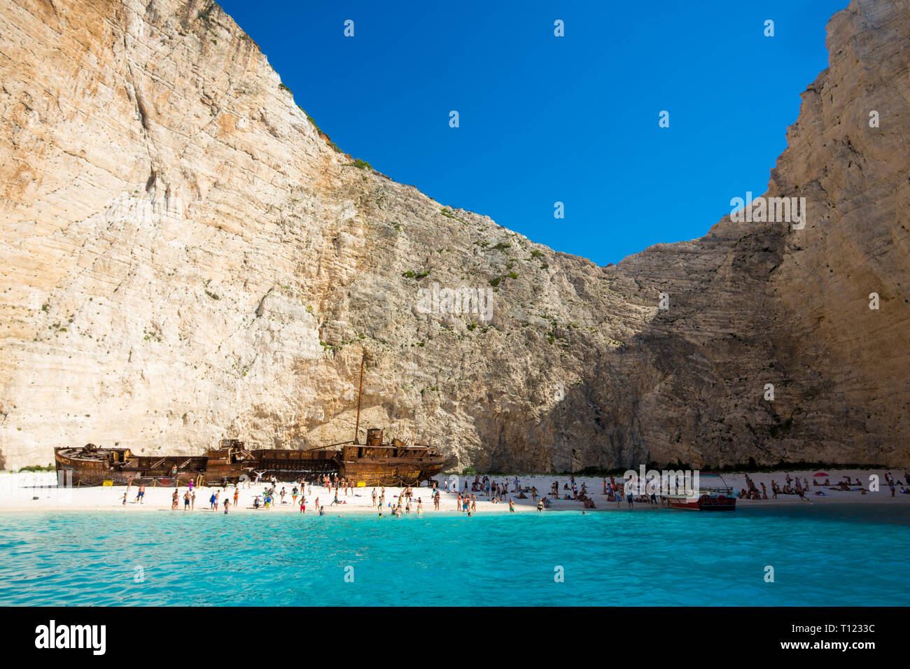 Greece, Zakynthos, Navagio. Famous shipwreck on a secluded beach with tourists. Stock Photo