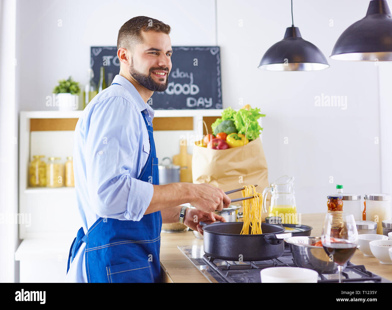 Smiling and confident chef standing in large kitchen Stock Photo