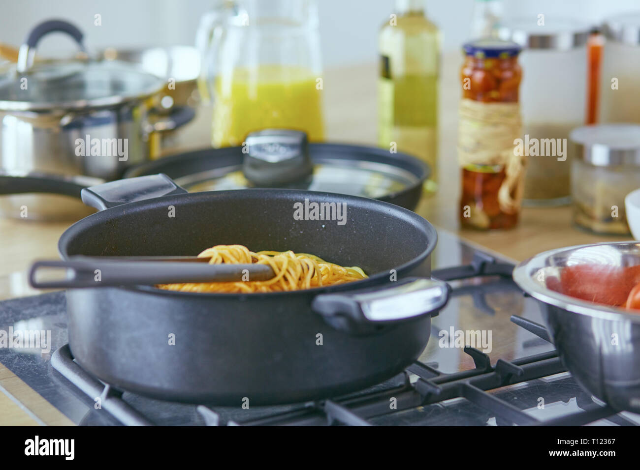 Pasta rolled on fork over pan on stove in the kitchen Stock Photo Alamy