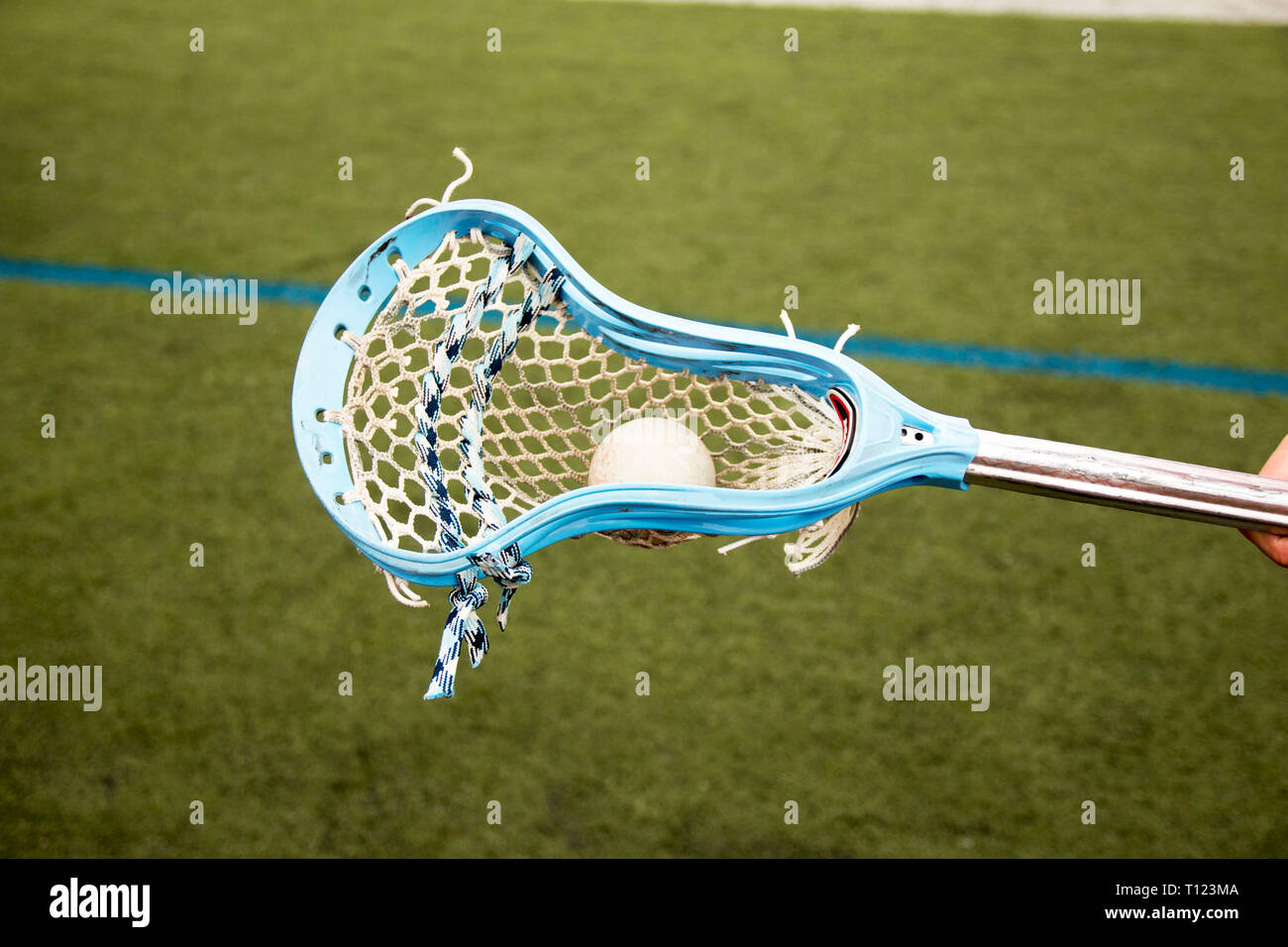 Carolina blue lacrosse stick carrying a ball Stock Photo