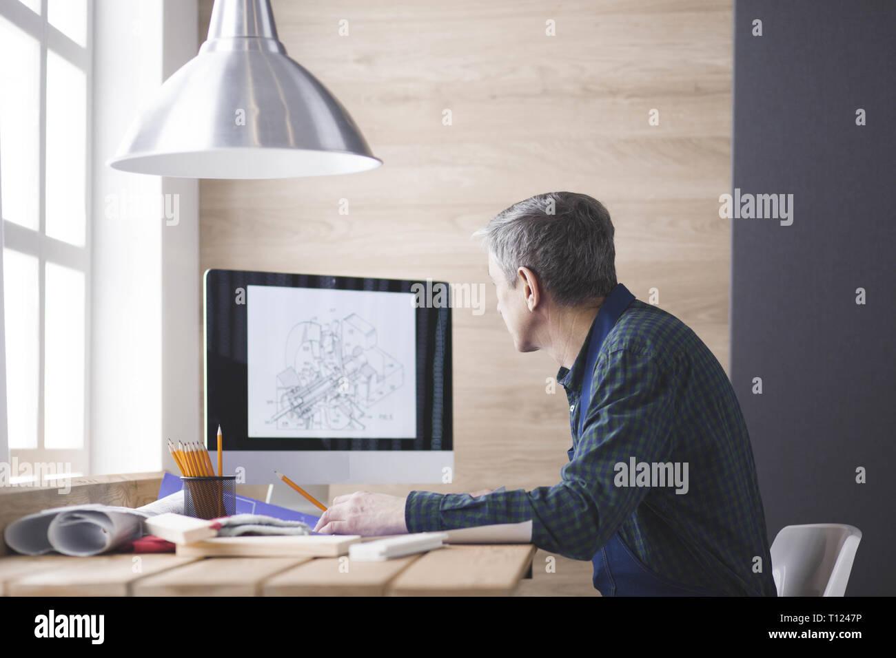 Engineer carpenter working on laptop and sketching project Stock Photo