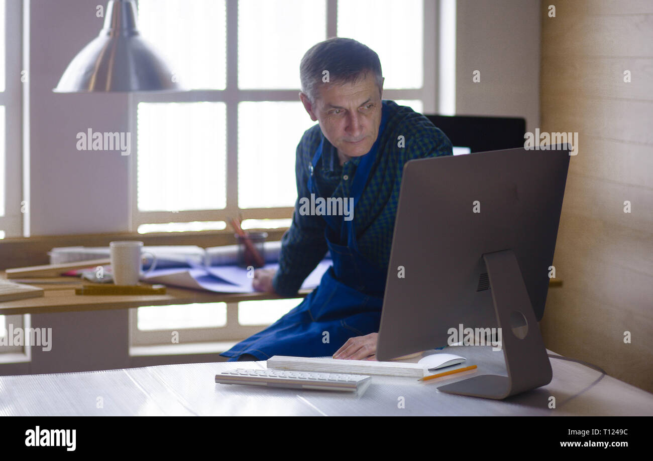 Engineer carpenter working on laptop and sketching project Stock Photo
