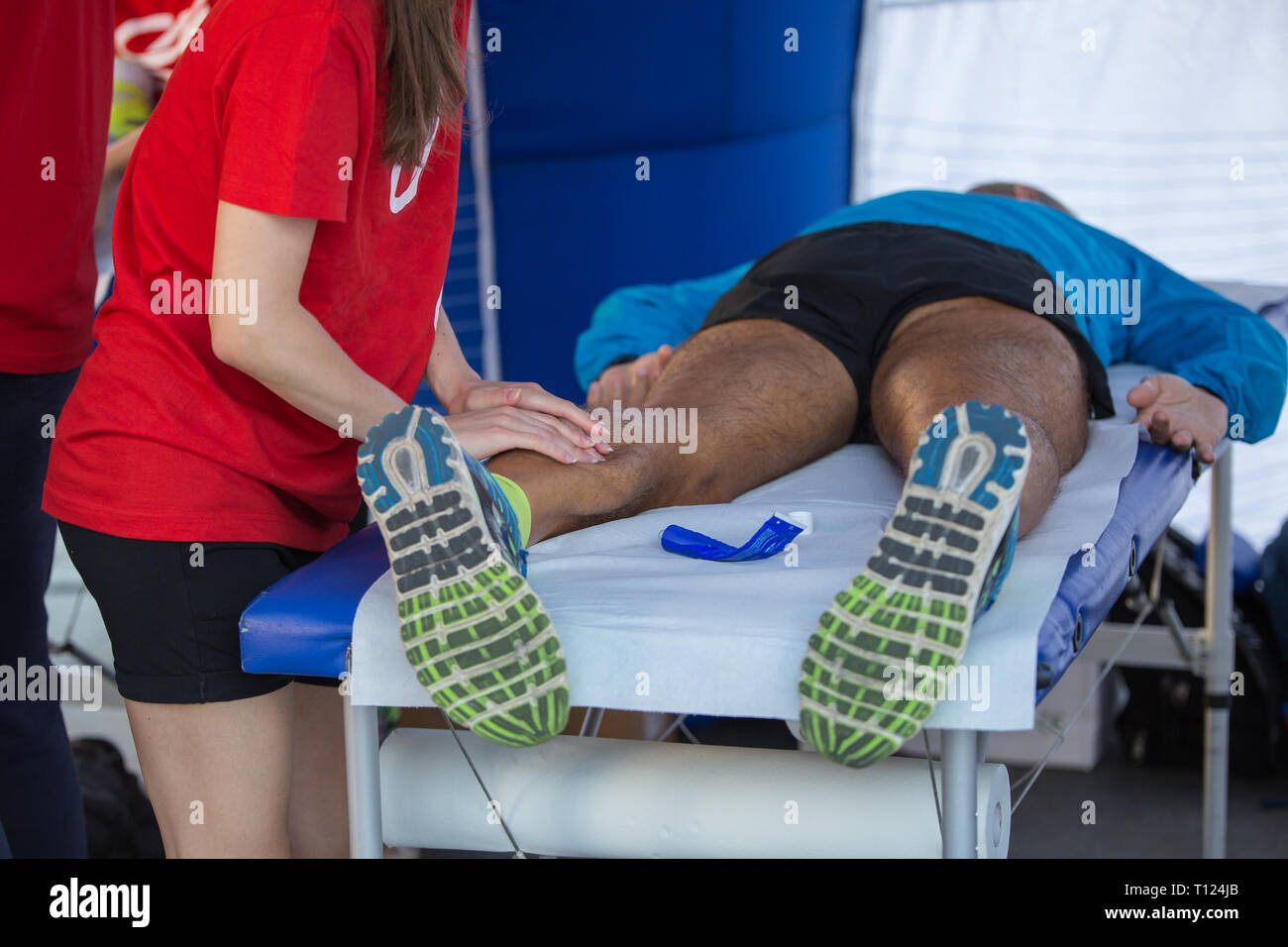 Athlete lying on a Bed while having Legs Massaged after a Physical