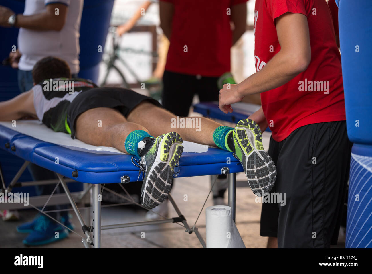 Athlete lying on a Bed while having Legs Massaged after a Physical