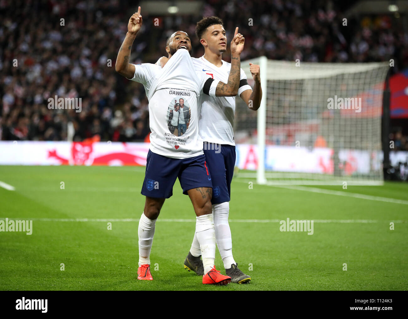 England's Raheem Sterling celebrates scoring his side's third goal of the game and shows a t-shirt in memory of former Crystal Palace youth player Damary Dawkins during the UEFA Euro 2020 Qualifying, Group A match at Wembley Stadium, London. Stock Photo