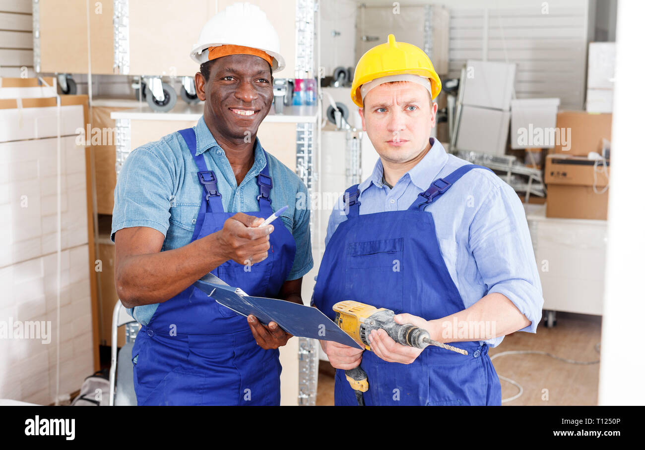 Professional male contractors discussing while determining scope of building work indoors Stock Photo
