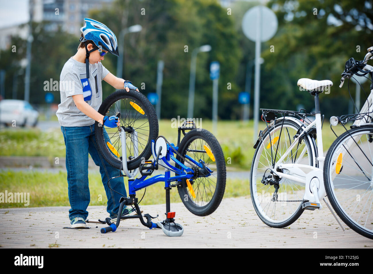Cute little boy repairing his bicycle outdoors Stock Photo