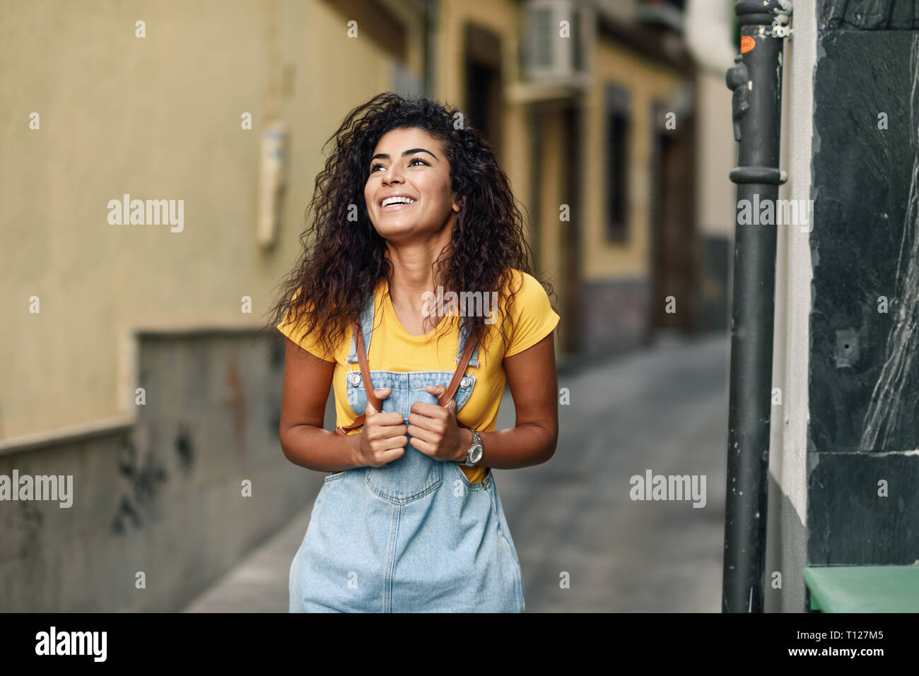 Young North African Woman With Black Curly Hairstyle Outdoors Stock young-north-african-woman-with-black-curly-hairstyle-outdoors-stock