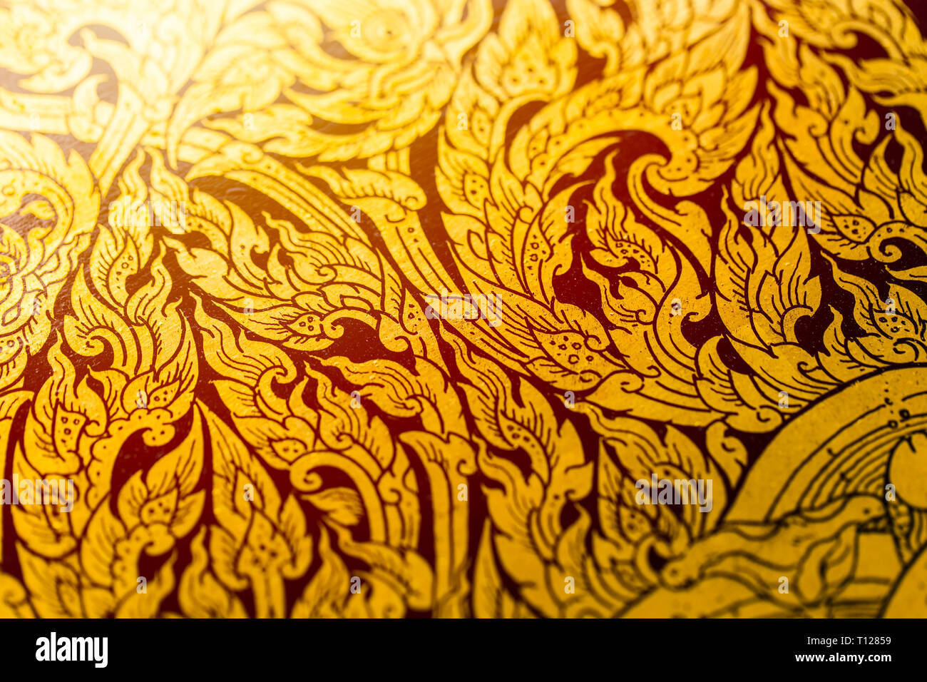 Thai magnificent antique art pattern gold color paint on wooden texture in temple. Stock Photo