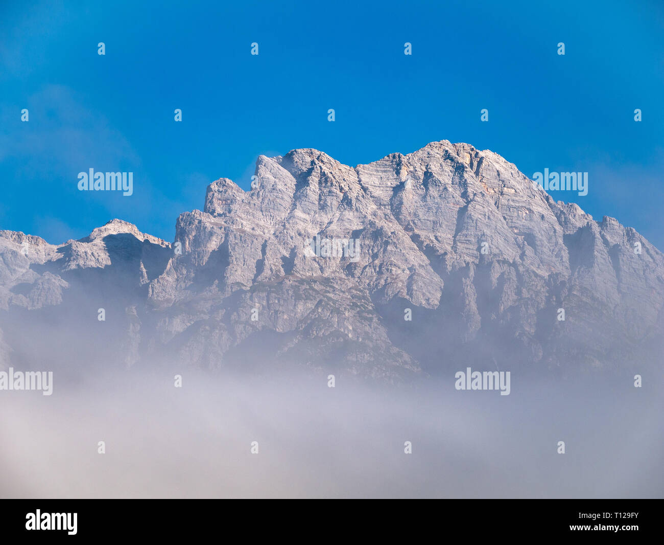 image of mountain peak with clouds in the alps Stock Photo - Alamy