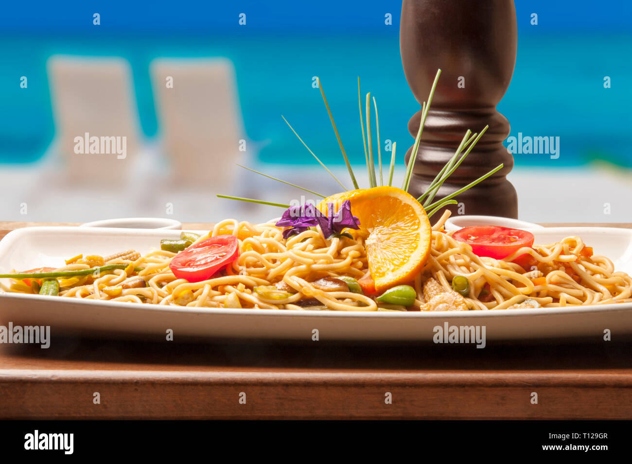 On the beach, a restaurant at the seaside and a chinese noodle at a restaurant. A nice menu to choose from for a delicious dinner. Stock Photo