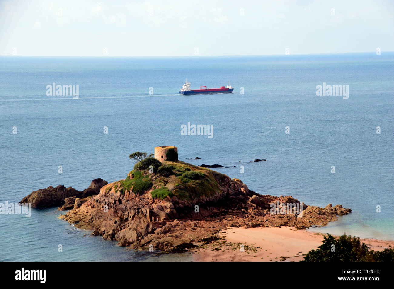 Cargo Ship Passing Portelet Tower on a Rocky Tidal Island in Portlet